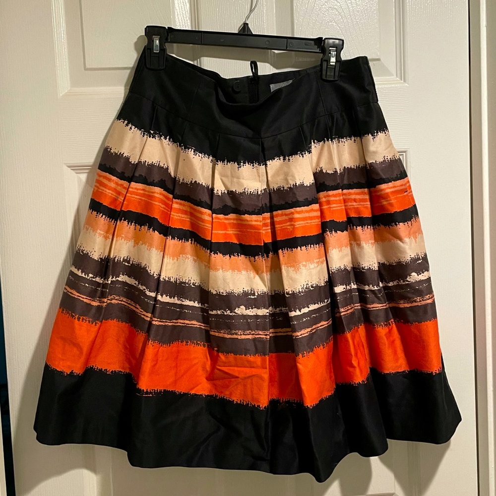 Women’s pleated skirt in black and shades of coral. Size 12 from H&M